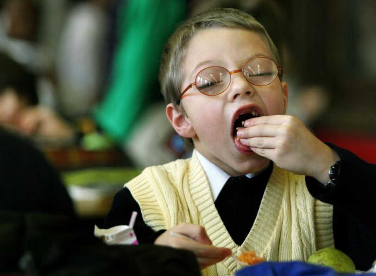 Bambino che mangia a scuola
