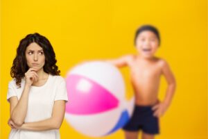 bimbo in costume da bagno sullo sfondo e donna pensierosa