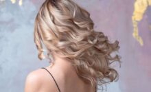 donna bionda di spalle con capelli lunghi e ondulati