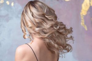 donna bionda di spalle con capelli lunghi e ondulati